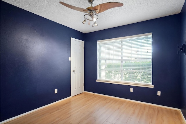 empty room with ceiling fan, light hardwood / wood-style floors, and a textured ceiling