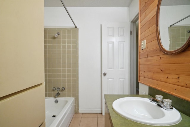 bathroom with tile patterned flooring, tiled shower / bath, and vanity