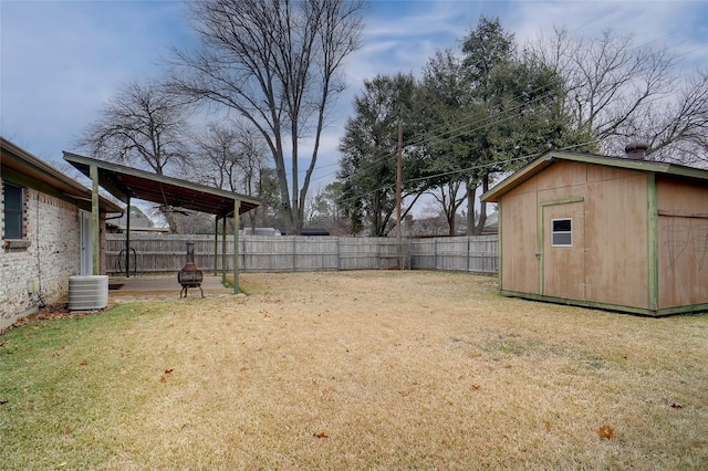 view of yard featuring a storage shed and central AC