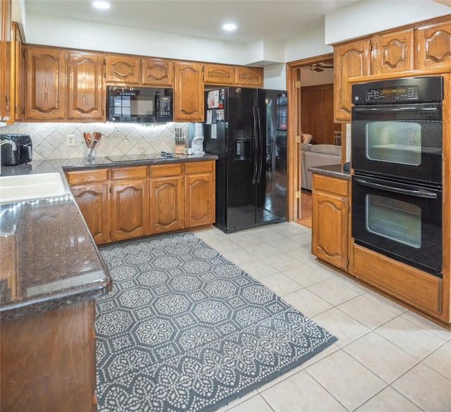 kitchen featuring sink, tasteful backsplash, light tile patterned floors, ceiling fan, and black appliances