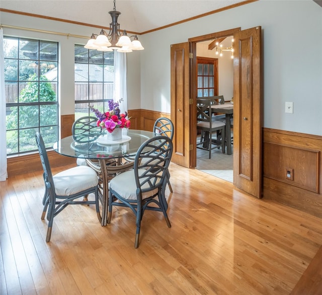 dining area featuring crown molding, light hardwood / wood-style floors, a chandelier, and a healthy amount of sunlight