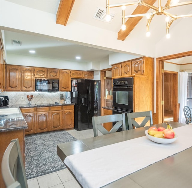 kitchen featuring light tile patterned floors, lofted ceiling with beams, decorative backsplash, black appliances, and decorative light fixtures