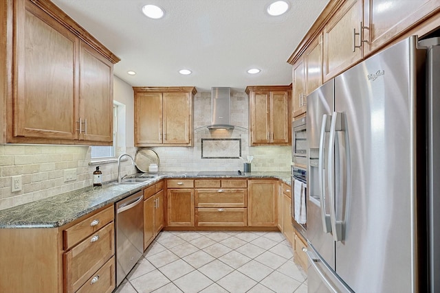 kitchen featuring wall chimney exhaust hood, sink, light tile patterned floors, dark stone countertops, and stainless steel appliances