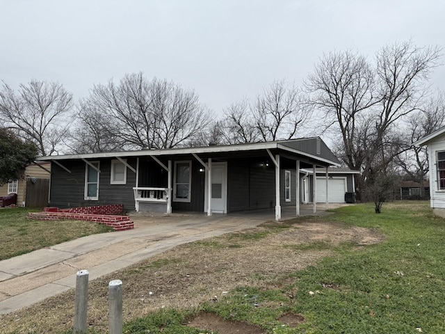 view of front of house featuring a carport, a garage, and a front lawn