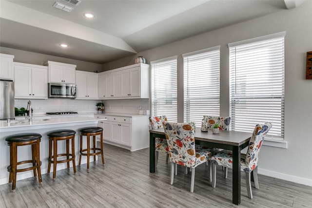 kitchen with white cabinetry, fridge, sink, and decorative backsplash