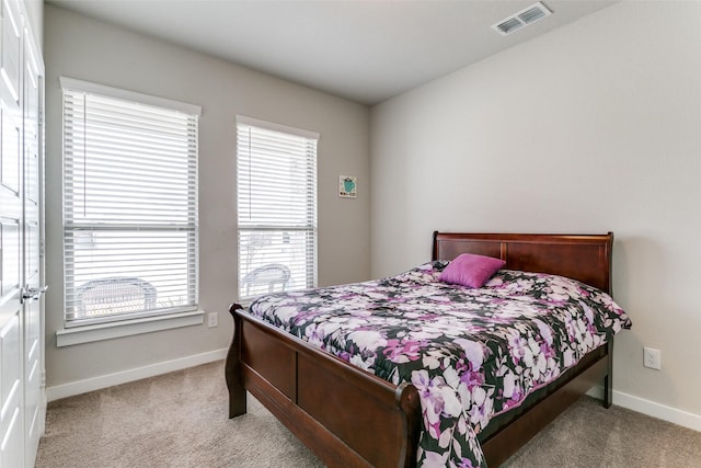 bedroom featuring multiple windows and light carpet