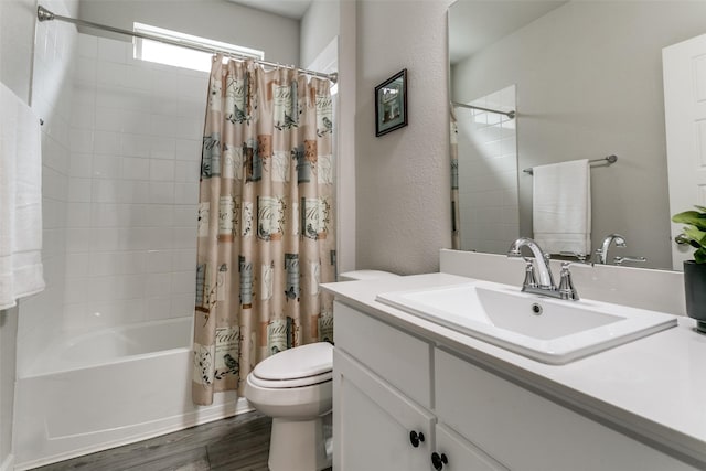 full bathroom with hardwood / wood-style flooring, vanity, shower / tub combo, and toilet