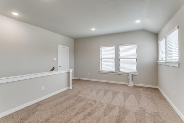 carpeted spare room featuring lofted ceiling