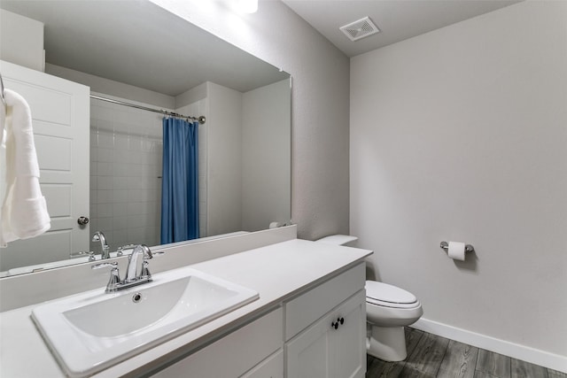 bathroom with a shower with curtain, vanity, hardwood / wood-style floors, and toilet