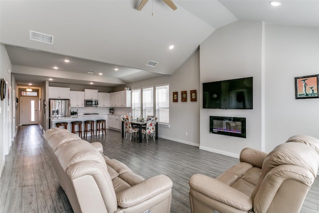 living room with ceiling fan, high vaulted ceiling, and dark hardwood / wood-style flooring