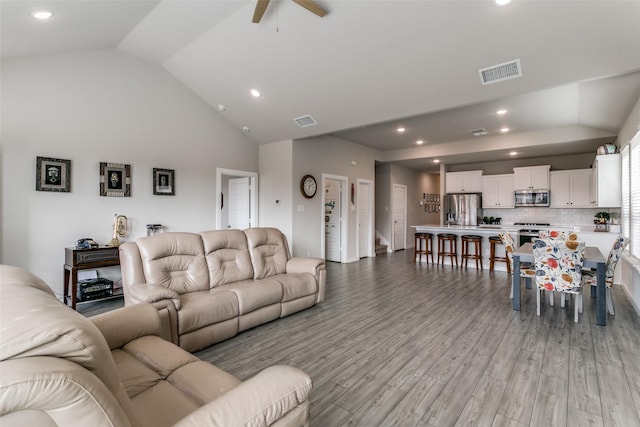 living room with ceiling fan, high vaulted ceiling, and light hardwood / wood-style flooring