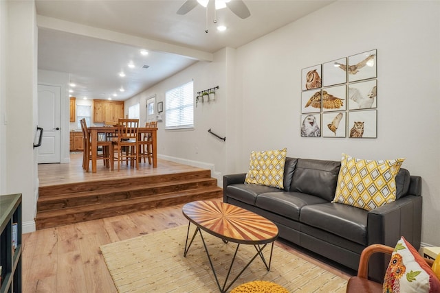 living room with baseboards, recessed lighting, ceiling fan, beamed ceiling, and light wood-type flooring