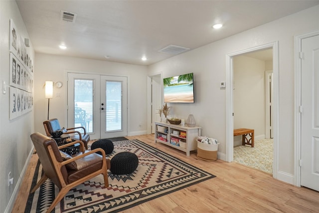 sitting room with wood finished floors, recessed lighting, french doors, and visible vents