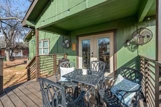 wooden terrace featuring french doors and outdoor dining area