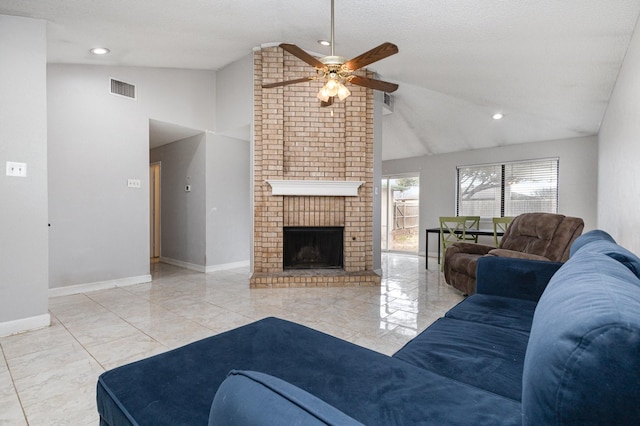 living room featuring vaulted ceiling, a brick fireplace, a textured ceiling, and ceiling fan