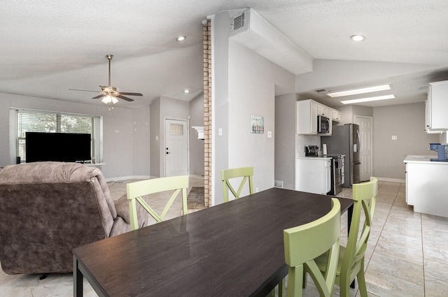 dining area featuring lofted ceiling, a textured ceiling, and ceiling fan