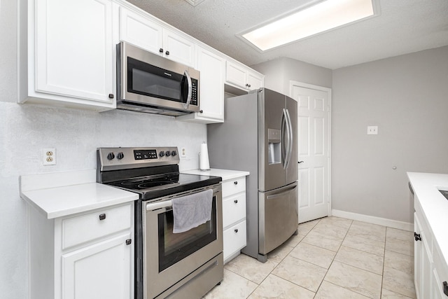 kitchen with light tile patterned floors, a textured ceiling, white cabinets, and appliances with stainless steel finishes