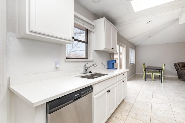 kitchen featuring white cabinetry, dishwasher, sink, and a wealth of natural light