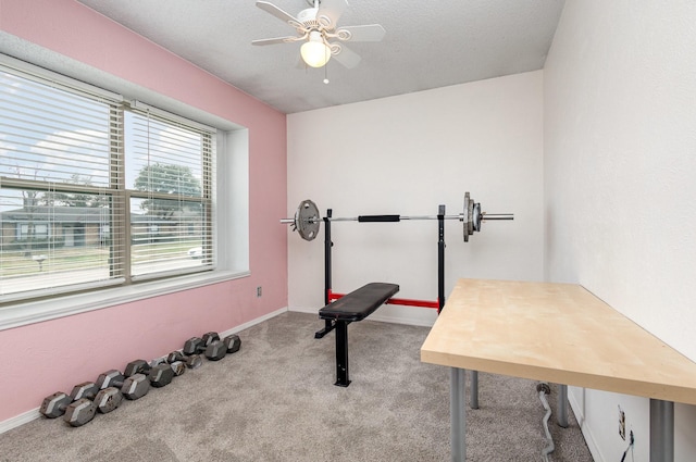 exercise area with ceiling fan, light carpet, and a textured ceiling