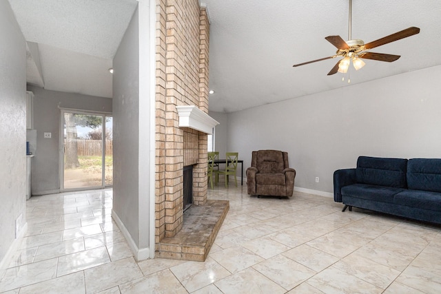 living room with ceiling fan, vaulted ceiling, a brick fireplace, and a textured ceiling