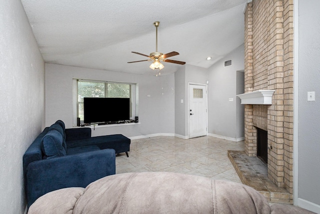 living room with ceiling fan, vaulted ceiling, a brick fireplace, and a textured ceiling