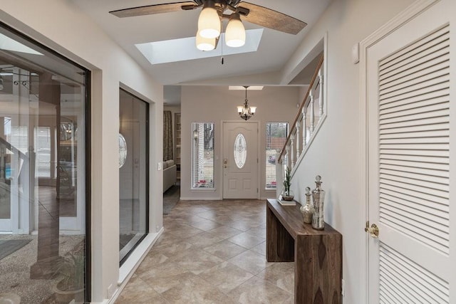 foyer entrance with ceiling fan with notable chandelier