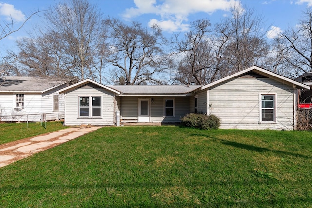 rear view of house featuring a lawn