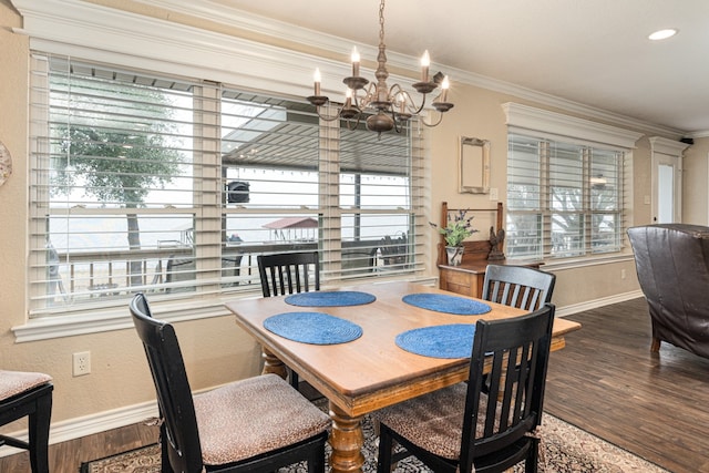 dining space with crown molding, an inviting chandelier, hardwood / wood-style floors, and plenty of natural light