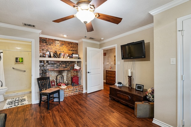 interior space featuring ornamental molding, a brick fireplace, dark hardwood / wood-style floors, and ceiling fan