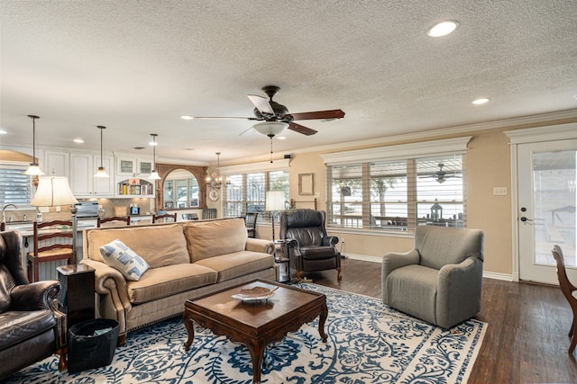 living room featuring sink, dark hardwood / wood-style floors, ornamental molding, a textured ceiling, and ceiling fan with notable chandelier