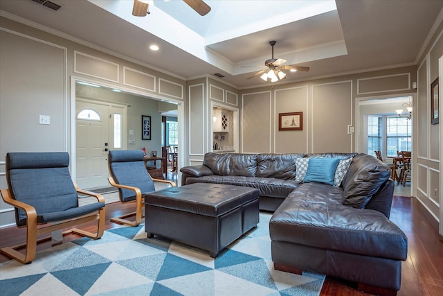 living room featuring hardwood / wood-style floors, ornamental molding, a wealth of natural light, and a tray ceiling