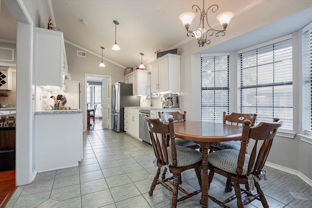 tiled dining area with sink, crown molding, vaulted ceiling, and a chandelier