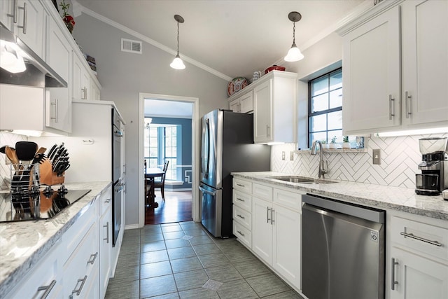 kitchen with stainless steel appliances, white cabinetry, hanging light fixtures, and lofted ceiling