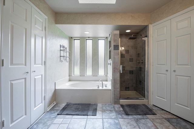 bathroom featuring a skylight and plus walk in shower