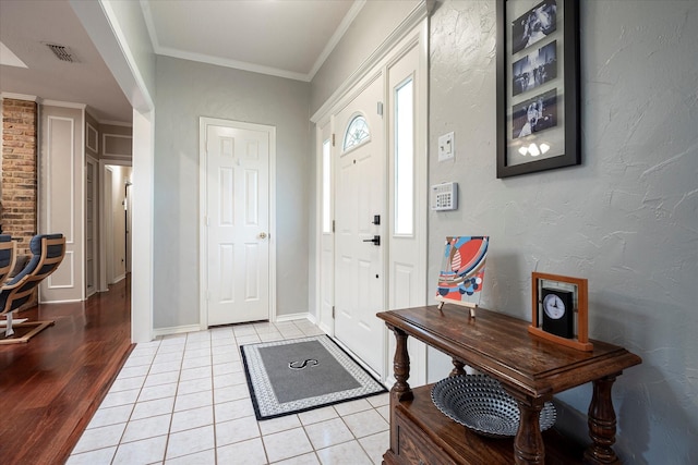 tiled foyer entrance featuring ornamental molding