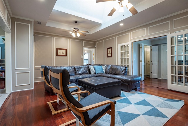 living room with a tray ceiling, crown molding, and dark hardwood / wood-style floors