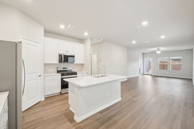 kitchen featuring a center island with sink, tasteful backsplash, stainless steel appliances, white cabinets, and sink