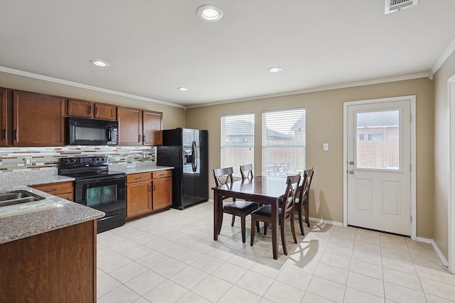 kitchen with backsplash, crown molding, plenty of natural light, and black appliances