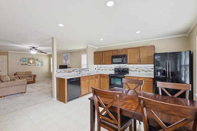 kitchen featuring sink, ornamental molding, black appliances, light carpet, and decorative backsplash