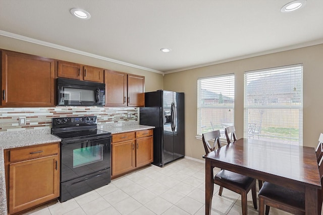 kitchen with backsplash, ornamental molding, light stone countertops, and black appliances