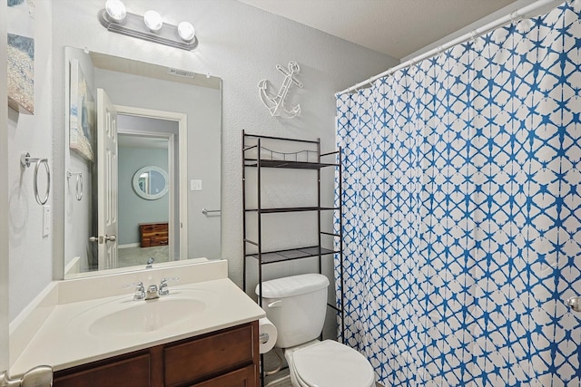 bathroom featuring vanity, curtained shower, and toilet