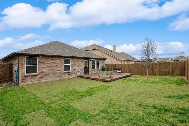 back of property with a wooden deck and a lawn