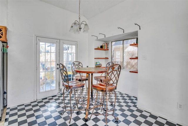 dining space with vaulted ceiling, a chandelier, and french doors