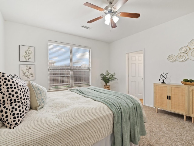 bedroom with light carpet, visible vents, and a ceiling fan