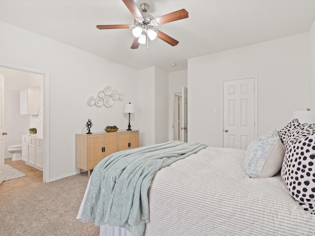 bedroom with light carpet, ceiling fan, baseboards, and connected bathroom