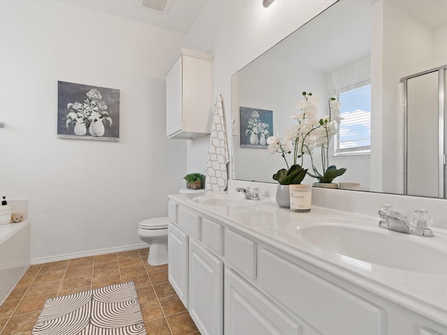 bathroom featuring double vanity, a sink, toilet, and a shower stall