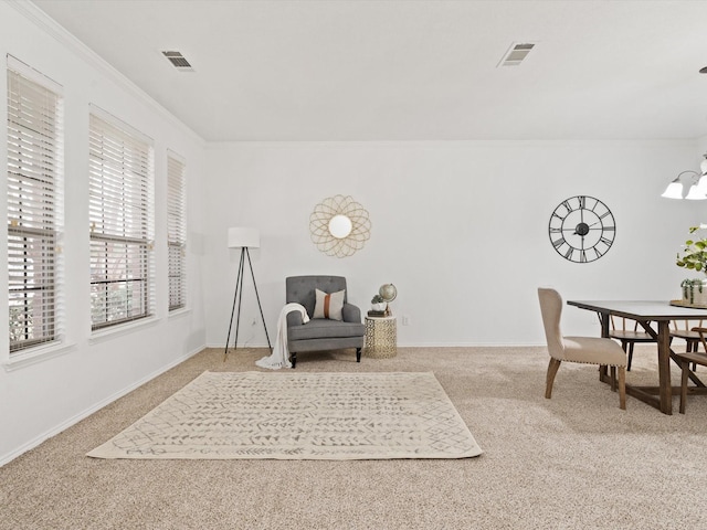 living area with carpet, visible vents, a notable chandelier, and ornamental molding