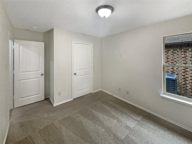 unfurnished bedroom with dark carpet