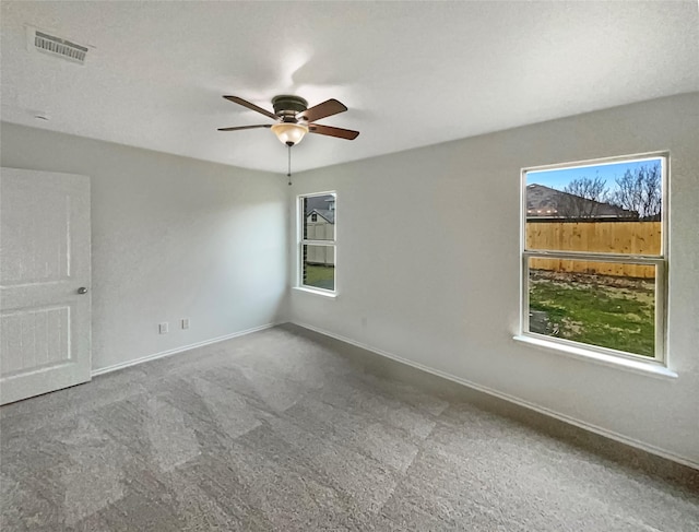 carpeted spare room featuring ceiling fan