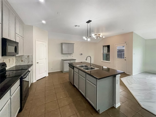 kitchen with pendant lighting, sink, gray cabinetry, a kitchen island with sink, and black appliances